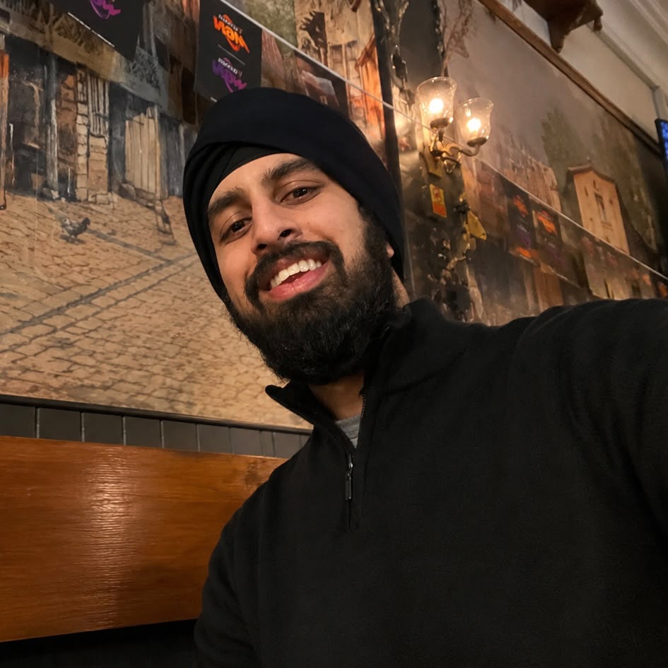 Nirmit smiling in front of a classical street mural