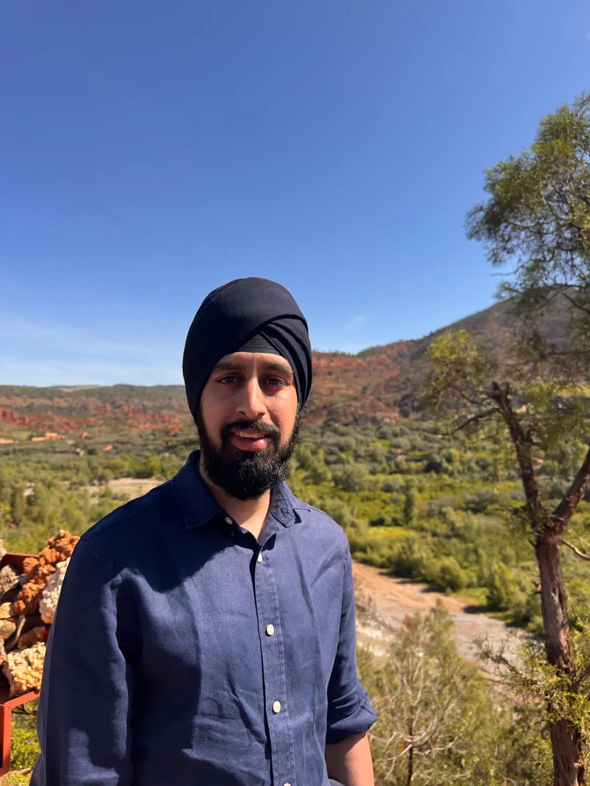 Nirmit in a blue shirt on a sunny hillside