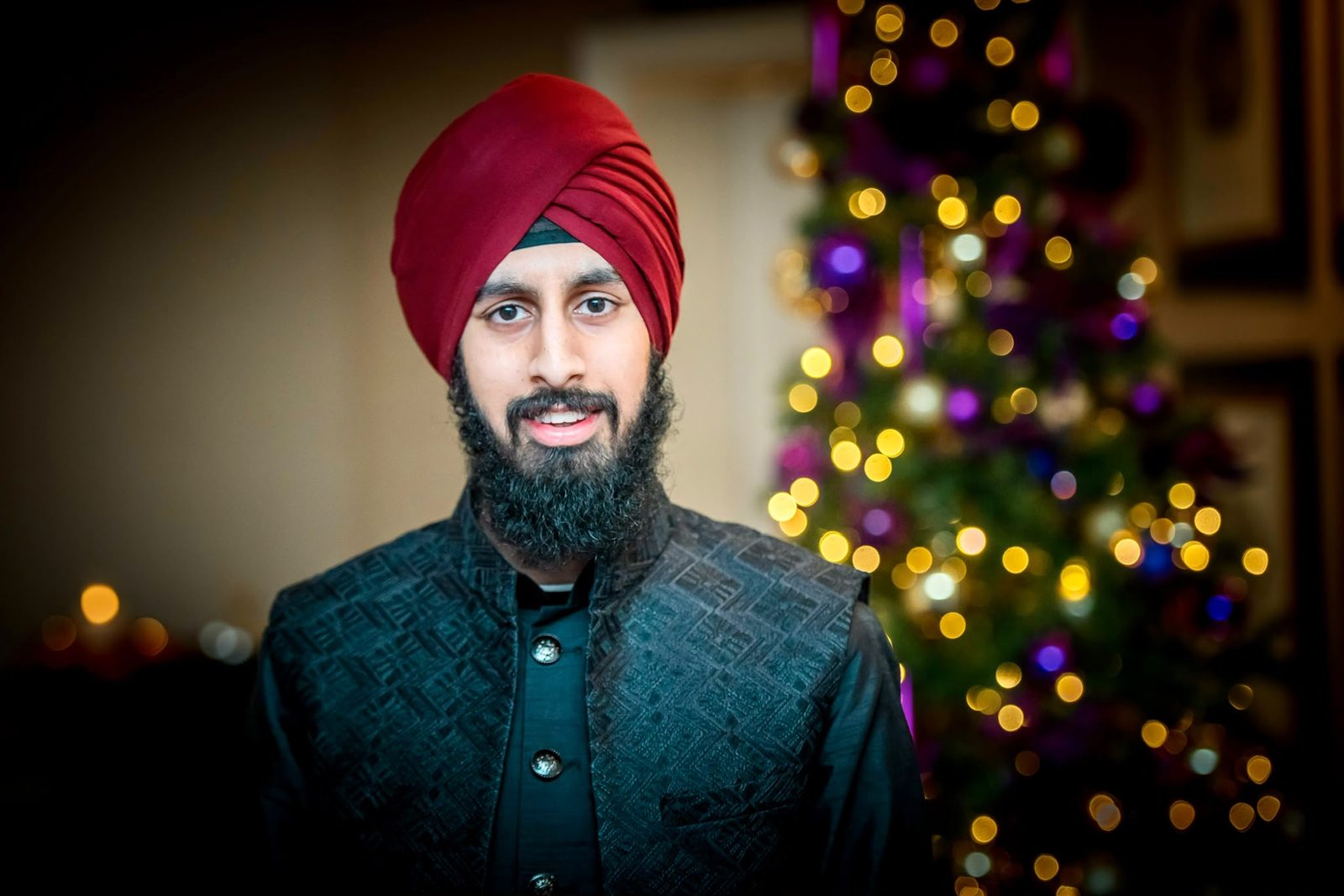 Portrait of Nirmit in a maroon turban beside a lit tree