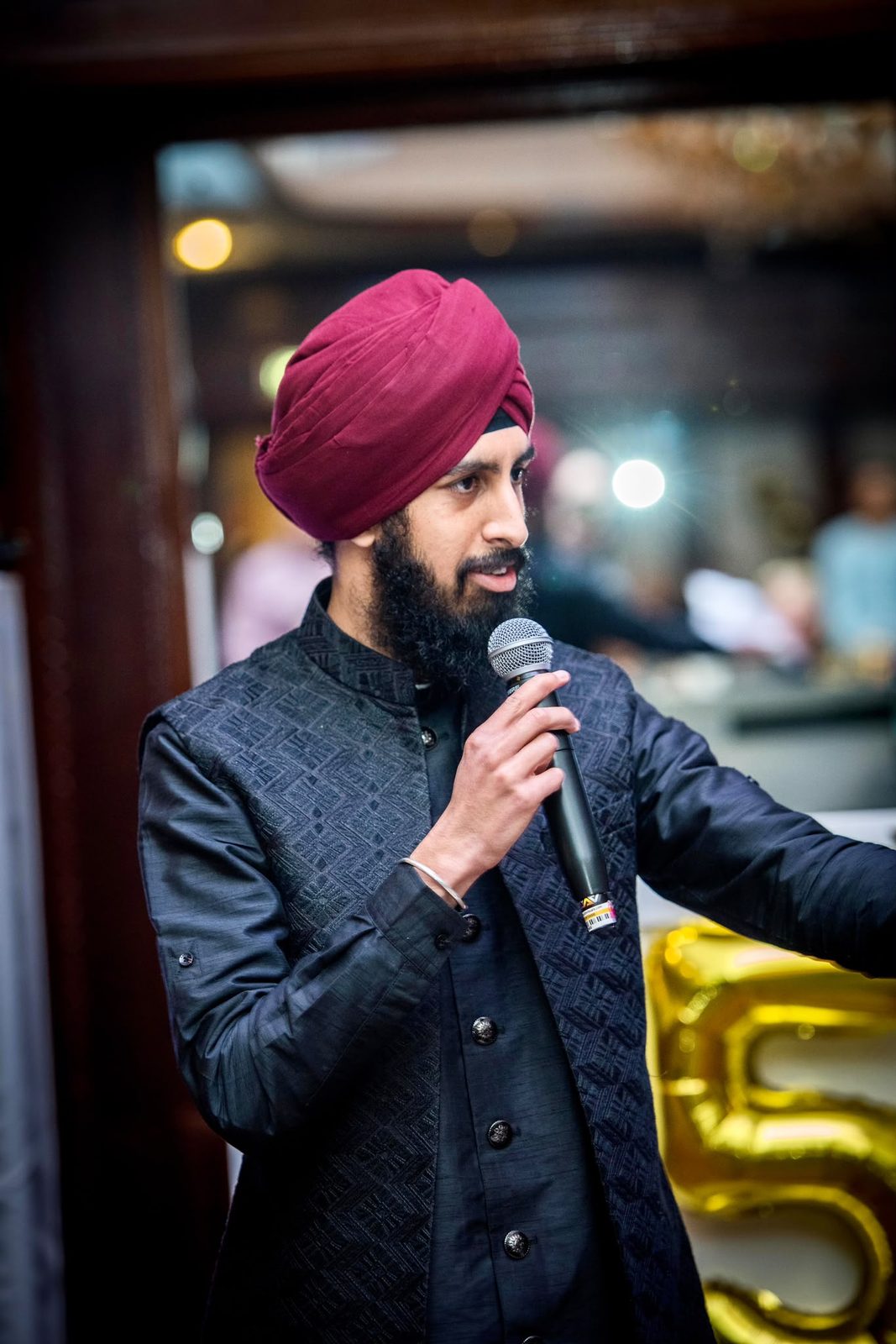 Nirmit speaking into a microphone at a celebration